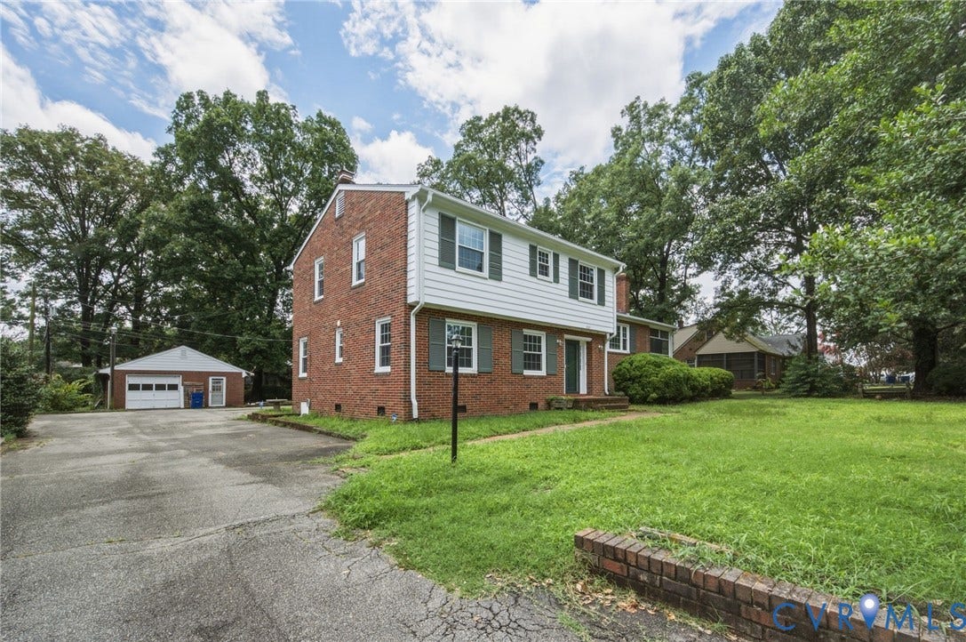 4021 Beulah Road, Chesterfield, VA 23237 Brick and siding exterior featuring green shutters, a paved driveway, and a detached garage
