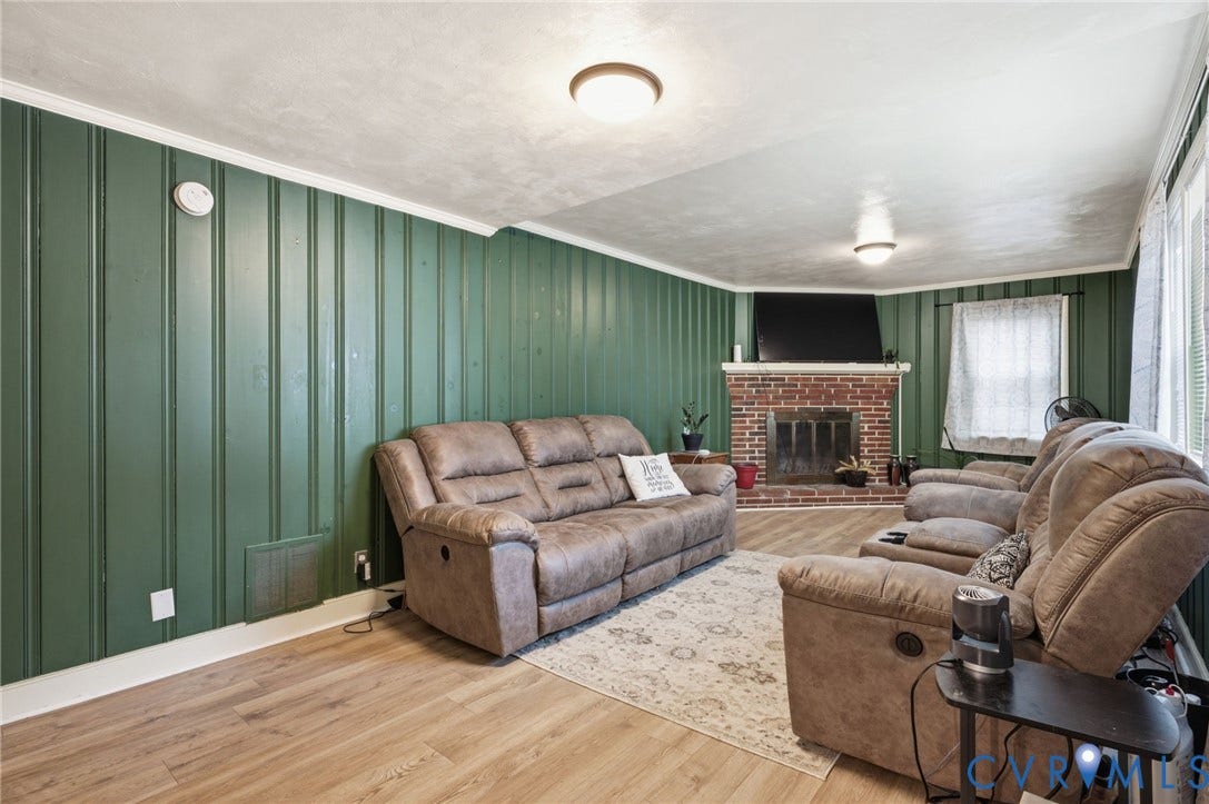 4021 Beulah Road, Chesterfield, VA 23237 Room featuring wood-finish flooring, vertical paneling, and a brick fireplace