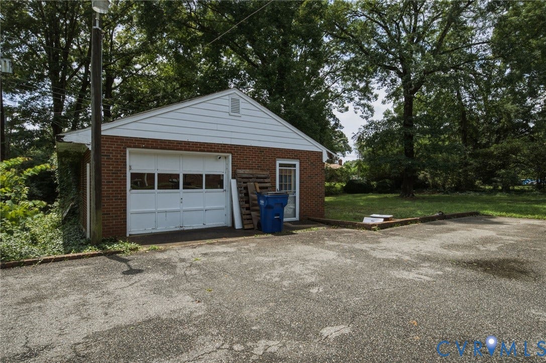 4021 Beulah Road, Chesterfield, VA 23237 Detached brick garage with a white overhead door featuring window inserts and a side entry door