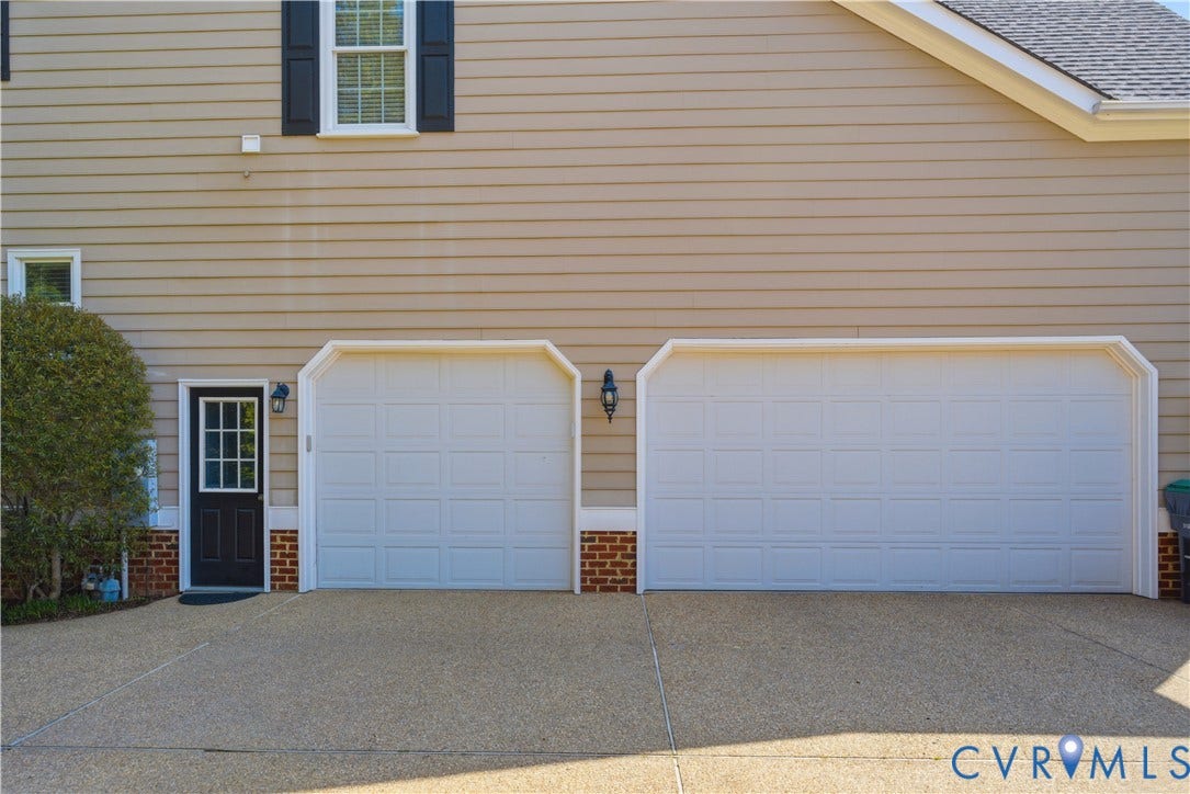 Side entry, three car garage and a side entry door featuring glass panels