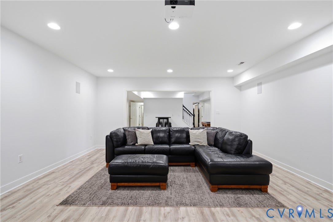 Spacious lower level featuring recessed lighting, light wood-finish flooring (LVP), white baseboards, and built-in ceiling speakers
