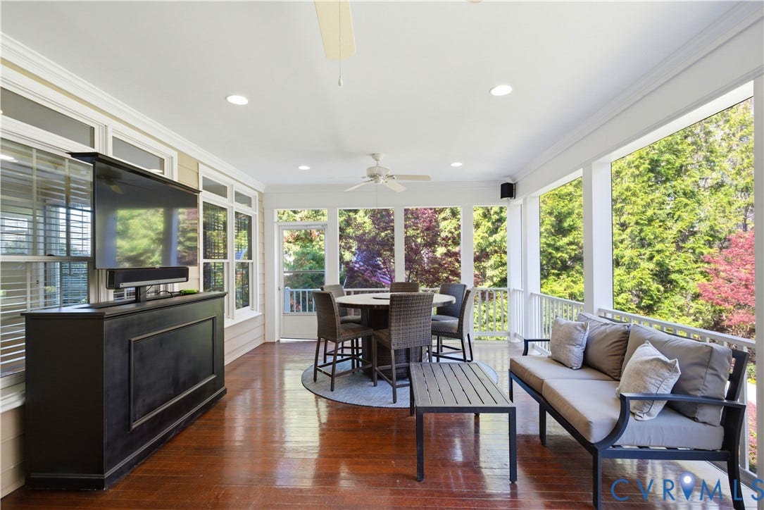 Spacious, screened porch with high-gloss wood-finish flooring, recessed lighting, and a ceiling fan