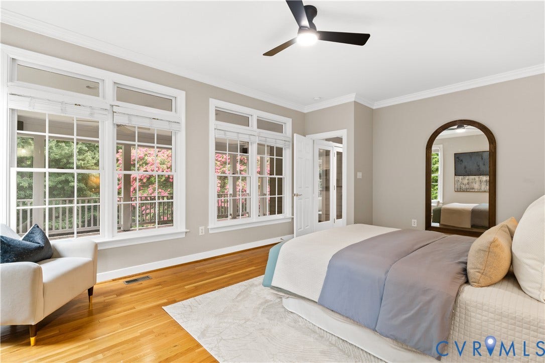 Hardwood flooring extends throughout this room, complemented by a contemporary ceiling fan with integrated lighting