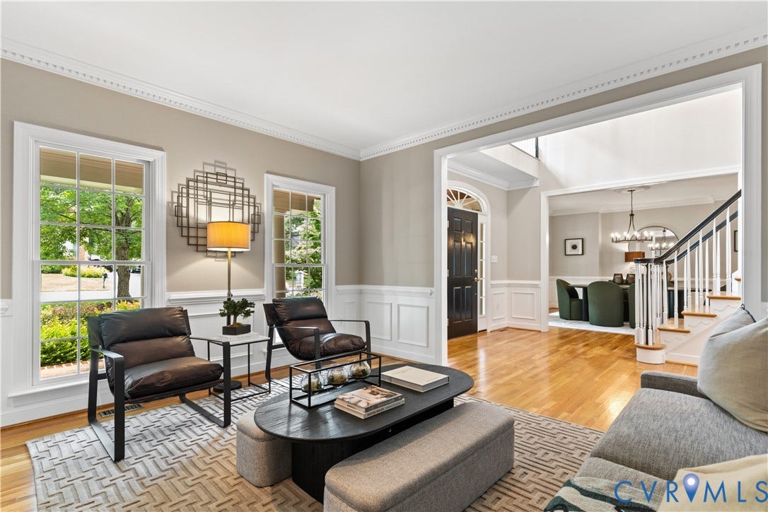 Hardwood flooring throughout, crown molding, and wainscoting details