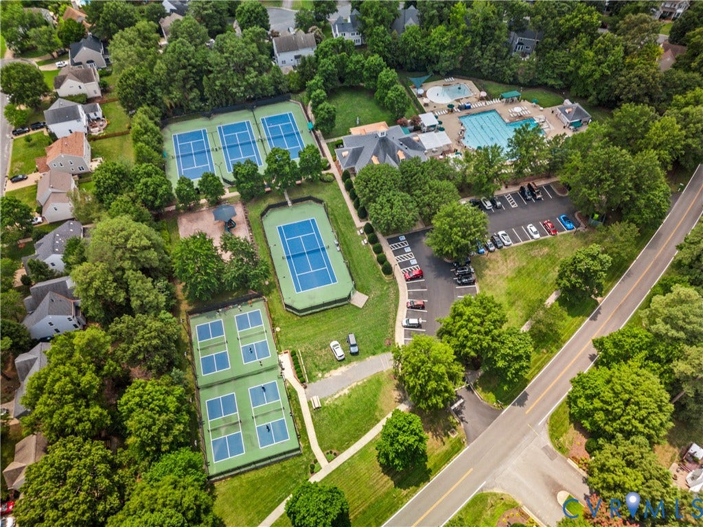 Aerial perspective showcasing multiple tennis courts, a swimming pool complex, and a clubhouse