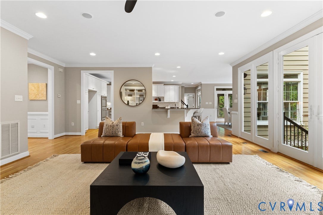 Spacious living area featuring wood-finish flooring, recessed lighting, and crown molding