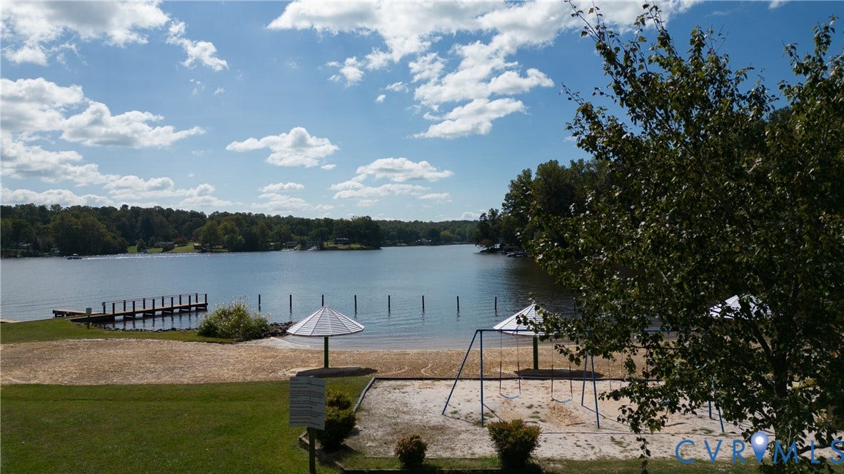 309 Ellis Drive, Louisa, VA 23093 Waterfront property featuring a private dock, sandy beach area, playground, and mature trees