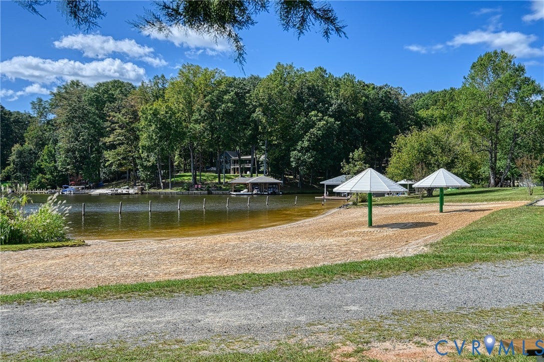309 Ellis Drive, Louisa, VA 23093 Sandy beach area with two permanent shade structures, bordered by a gravel path and green lawn