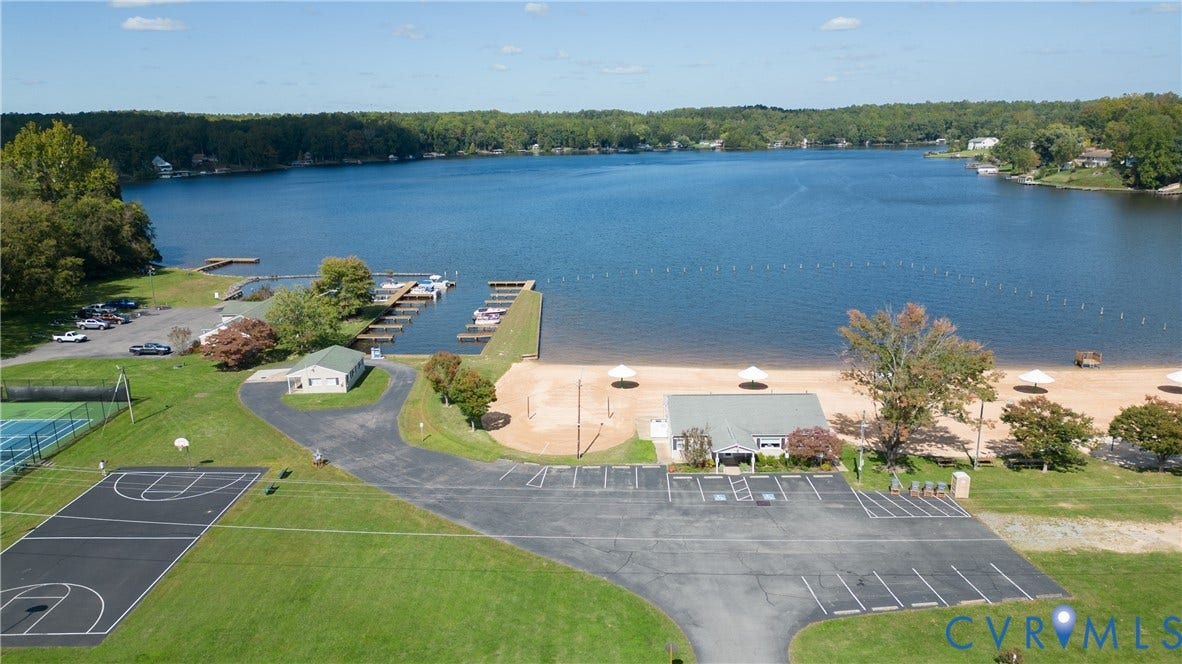 309 Ellis Drive, Louisa, VA 23093 Expansive lakefront setting featuring a sandy beach, boat docks, and a marked swimming area