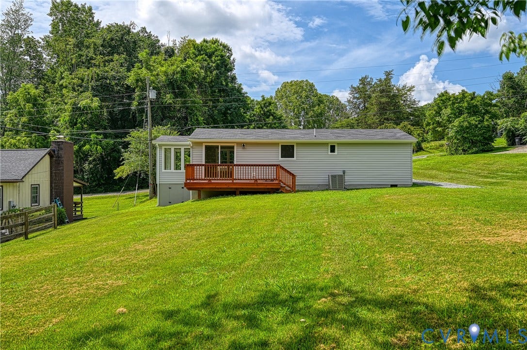 309 Ellis Drive, Louisa, VA 23093 Rear exterior featuring light-colored siding, a wood-finish deck with railings, and sliding glass doors