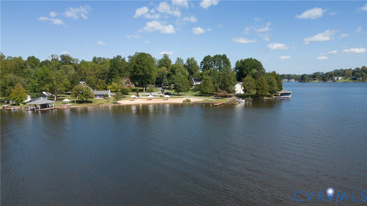 309 Ellis Drive, Louisa, VA 23093 Waterfront property featuring multiple boat docks, sandy beach areas, mature trees, and a clear expanse of water