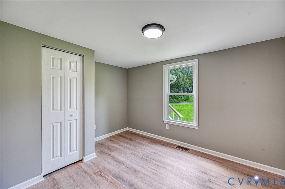 309 Ellis Drive, Louisa, VA 23093 Neutral wall paint, wood-finish flooring, white baseboards, and a bi-fold closet door