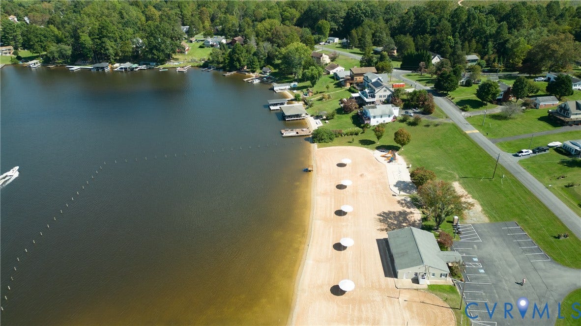 309 Ellis Drive, Louisa, VA 23093 Expansive lakefront property featuring a sandy beach, multiple boat docks, and a paved parking area