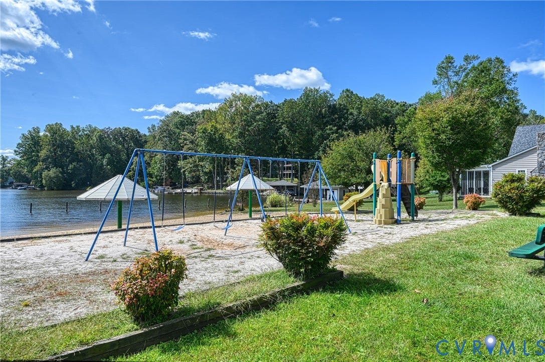 309 Ellis Drive, Louisa, VA 23093 Lakeside sand beach featuring a swing set, playground structure, and shaded seating areas