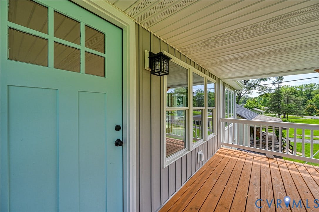 309 Ellis Drive, Louisa, VA 23093 Covered porch featuring a light blue entry door, wood-finish flooring, white railing, multi-pane windows, and gray vertical siding