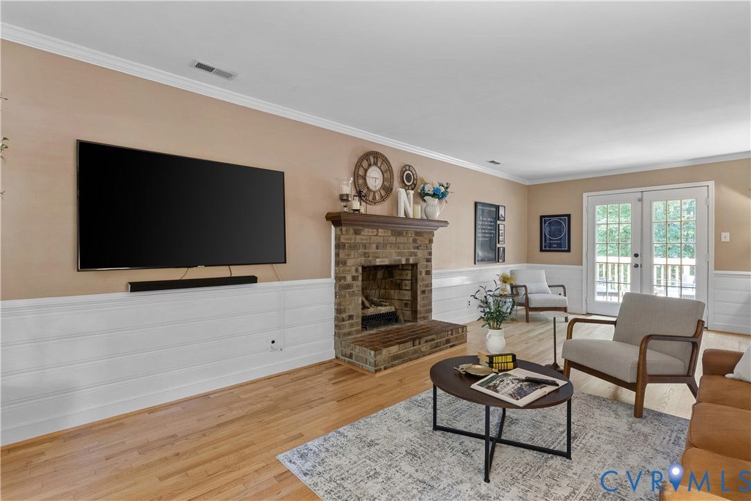 13908 Sterlings Bridge Road, Midlothian, VA 23112 Brick fireplace with a wood mantle, wood-finish flooring, white crown molding, and white wainscoting