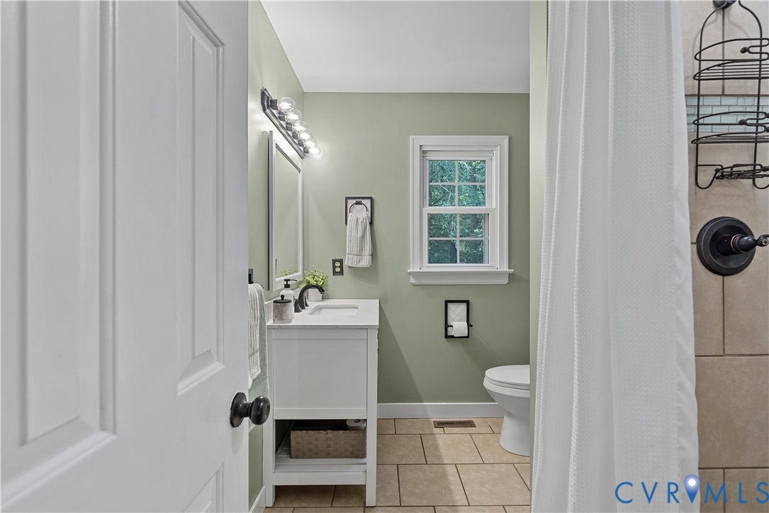 13908 Sterlings Bridge Road, Midlothian, VA 23112 Bathroom featuring a single vanity with storage, tiled flooring, a window, and a shower with a dark bronze fixture