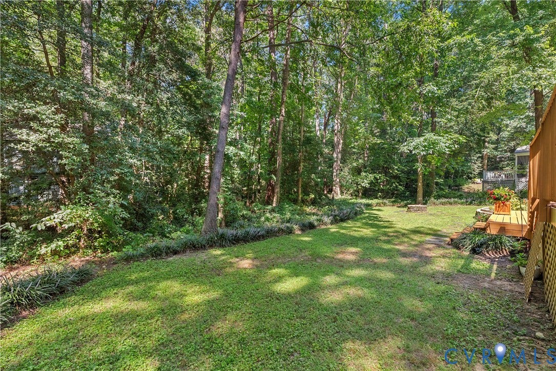 13908 Sterlings Bridge Road, Midlothian, VA 23112 Expansive backyard with mature trees, a manicured lawn, and a wooden deck