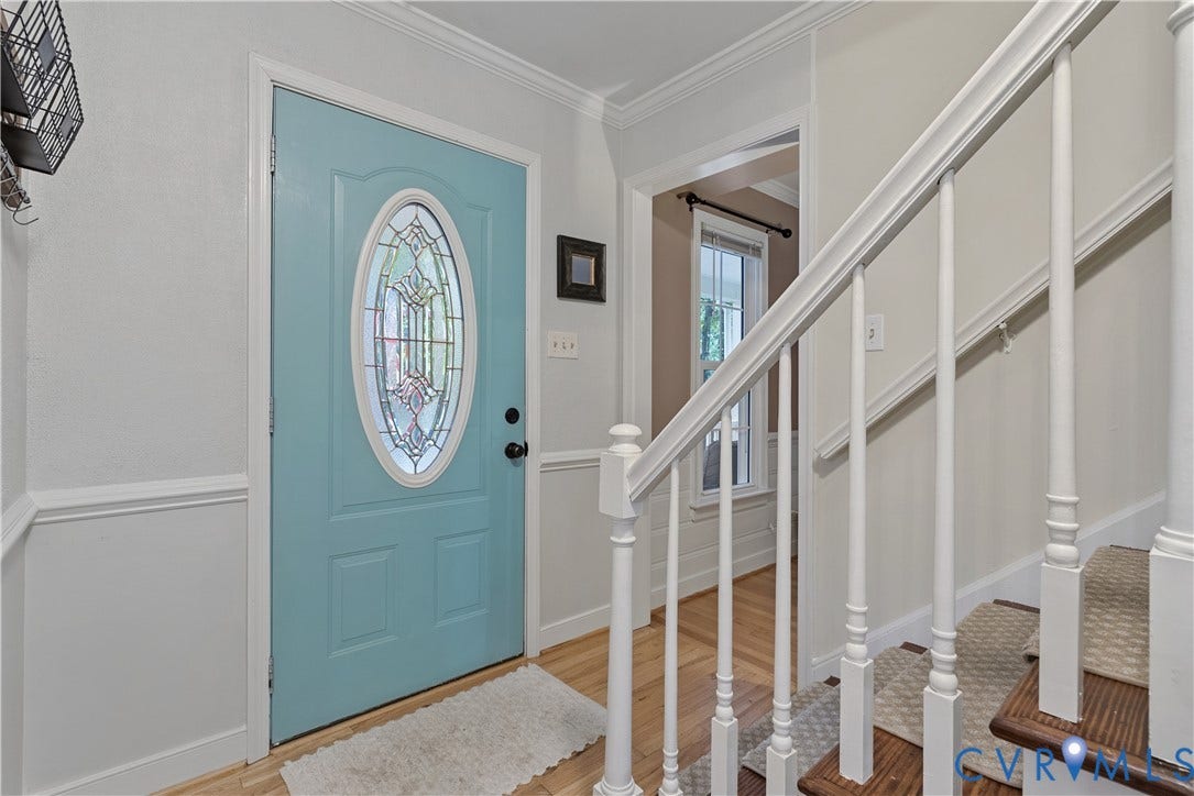 13908 Sterlings Bridge Road, Midlothian, VA 23112 Entryway featuring a decorative front door with an oval leaded glass insert, wood-finish flooring, white wainscoting, and a staircase with white spindles