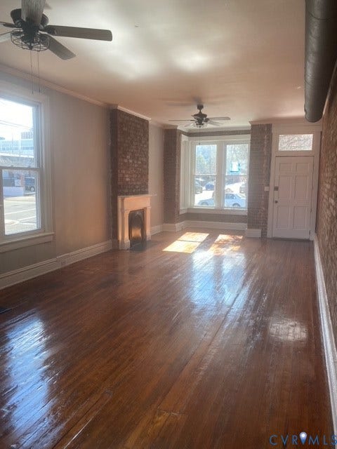 1100 W Marshall Street, Richmond, VA 23220 Interior space featuring wood-finish flooring, exposed brick accent walls, and a decorative fireplace with a light-toned mantel
