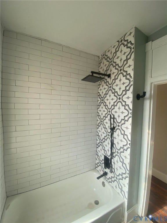 1100 W Marshall Street, Richmond, VA 23220 Bathtub shower featuring white subway tile surround, patterned accent tile, and matte black shower fixtures including a rainfall shower head and handheld sprayer