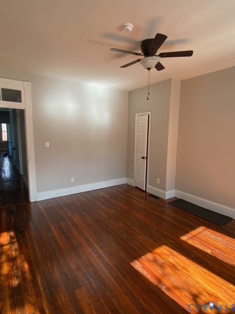 1100 W Marshall Street, Richmond, VA 23220 Spacious interior room featuring rich wood-finish flooring, light gray wall paint, white baseboards, and a ceiling fan with integrated lighting