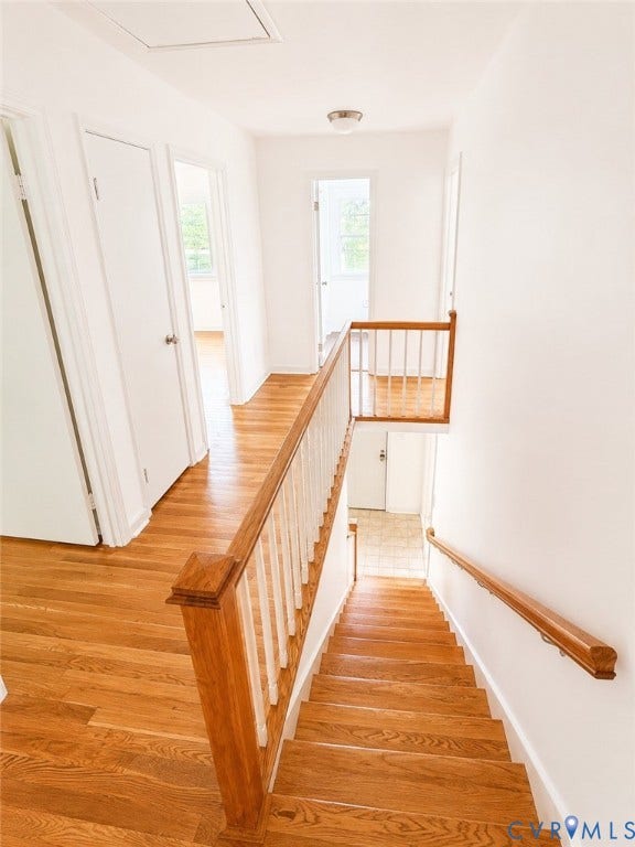 10250 Epsilon Road, Southwest, Richmond, VA 23235 Hardwood flooring throughout the upper level and staircase, featuring a wood baluster railing, white walls, and flush-mount ceiling lighting