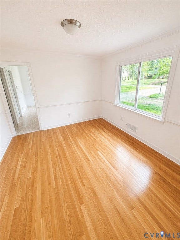 10250 Epsilon Road, Southwest, Richmond, VA 23235 Hardwood flooring throughout, featuring a large window, a two-tone wall treatment, crown molding, and a flush mount ceiling light