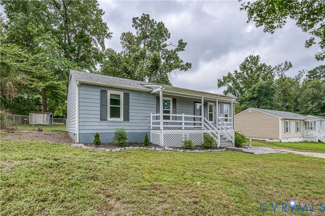 19105 Braebrook Drive, Chesterfield, VA 23834 Light blue siding exterior with dark gray shutters, a white railing porch, a gravel pathway, and a grassy front yard