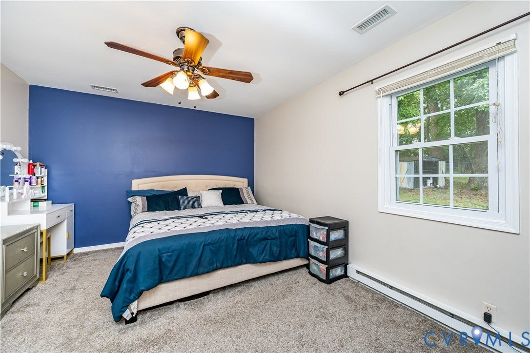 19105 Braebrook Drive, Chesterfield, VA 23834 Bedroom featuring a vibrant accent wall, neutral carpeting, and a window with white framing