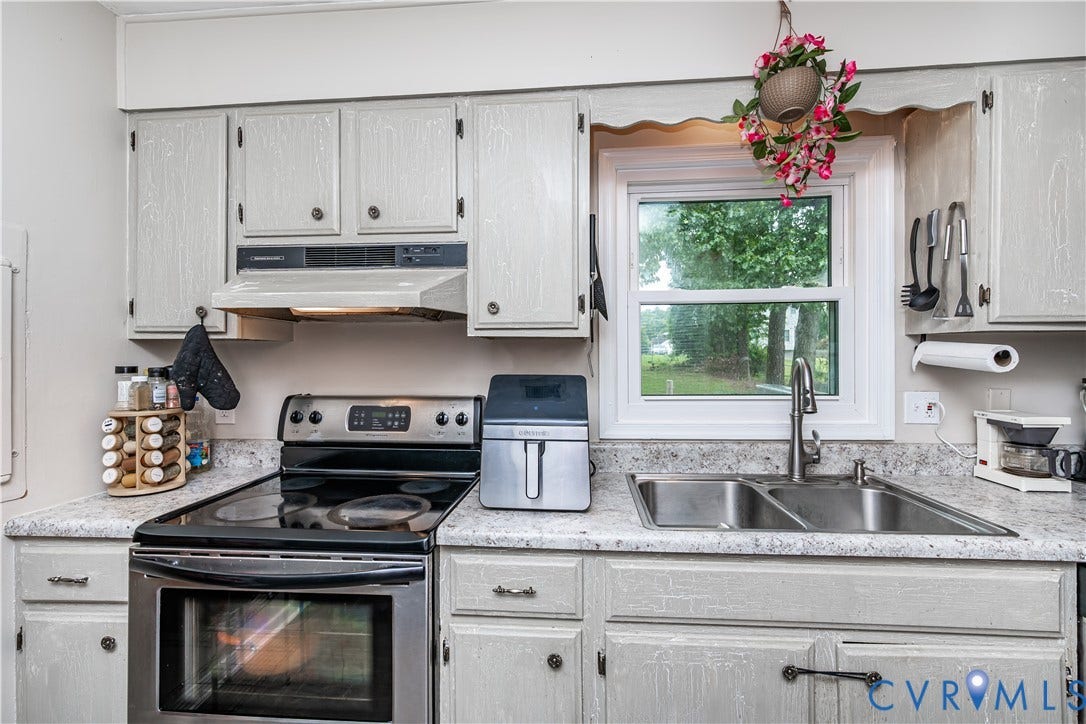 19105 Braebrook Drive, Chesterfield, VA 23834 Kitchen featuring light-toned cabinetry, stainless steel oven with cooktop, stainless steel double basin sink with high-arc faucet, speckled countertops, and a window