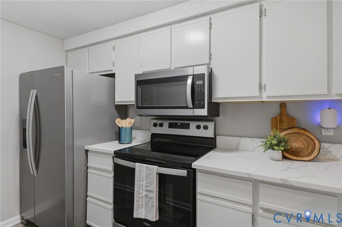 2460 Stembridge Court, #G, Richmond, VA 23238 Kitchen featuring white cabinetry, quartz countertops with veining, stainless steel microwave, and stainless steel electric range