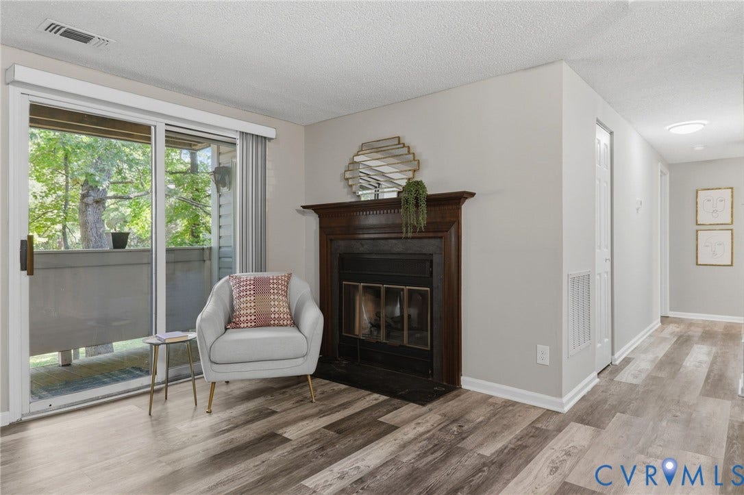 2460 Stembridge Court, #G, Richmond, VA 23238 Living area featuring l a dark wood fireplace surround with a metal firebox, and light gray wall paint
