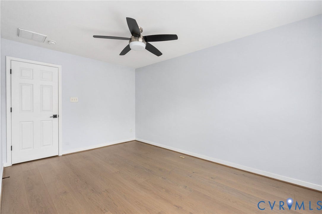 5806 Park Creste Drive, Glen Allen, VA 23059 Spacious room featuring wood-finish flooring, light blue walls, and a white six-panel door with a black handle