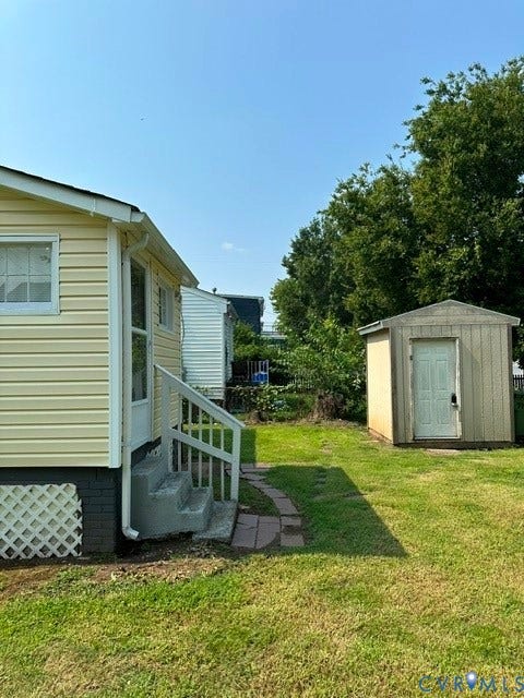 712 S Meadow Street, Richmond, VA 23220 Exterior featuring yellow vinyl siding, white trim, and a concrete staircase leading to a rear entrance