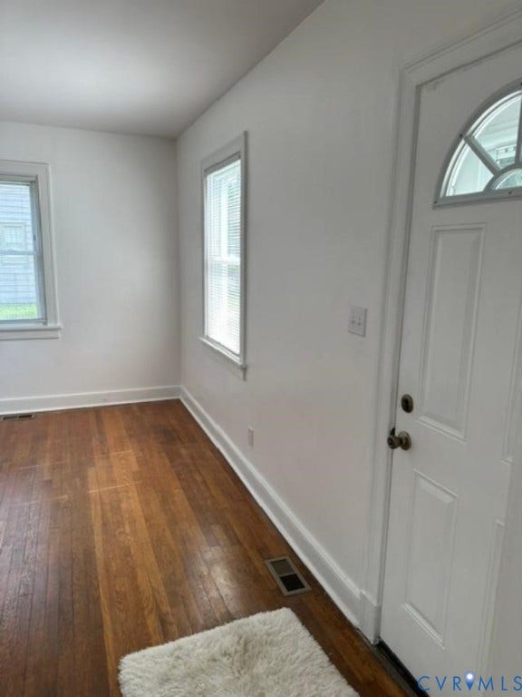 712 S Meadow Street, Richmond, VA 23220 Entryway featuring a white paneled door with an arched glass insert, rich wood-finish flooring, white baseboards, and bright white walls