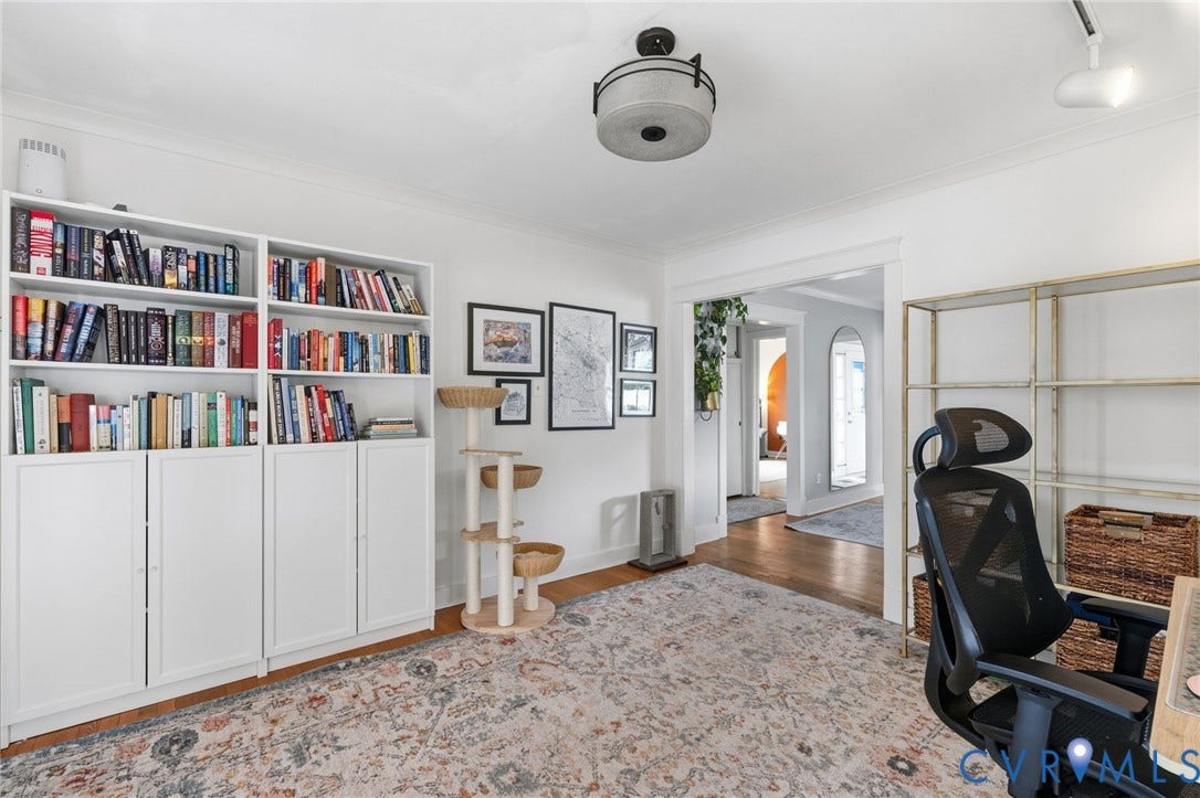 Defined office space with built-in white cabinetry, crown molding, and wood-finish flooring