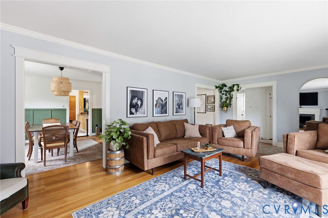 Bright living area featuring wood-finish flooring, light blue walls, and white crown molding