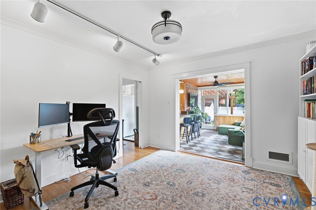 Hardwood flooring throughout, featuring a cased opening to an enclosed porch with checkerboard flooring