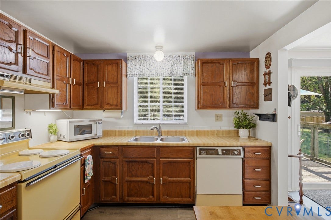 2007 Mountain Pine Boulevard, Three Pines, Richmond, VA 23235 Kitchen featuring wood-finish cabinetry, a double basin stainless steel sink, and a window with natural light