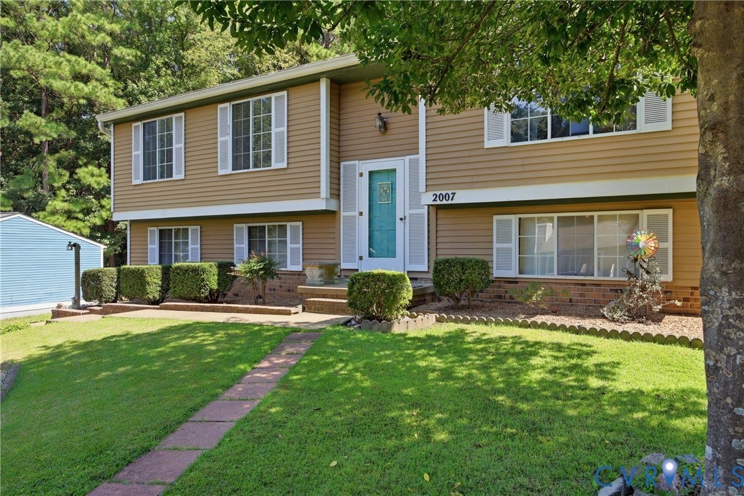 2007 Mountain Pine Boulevard, Three Pines, Richmond, VA 23235 Two-story residence featuring tan and gray fiber cement siding, a mint green entry door, and multi-pane windows across the faade
