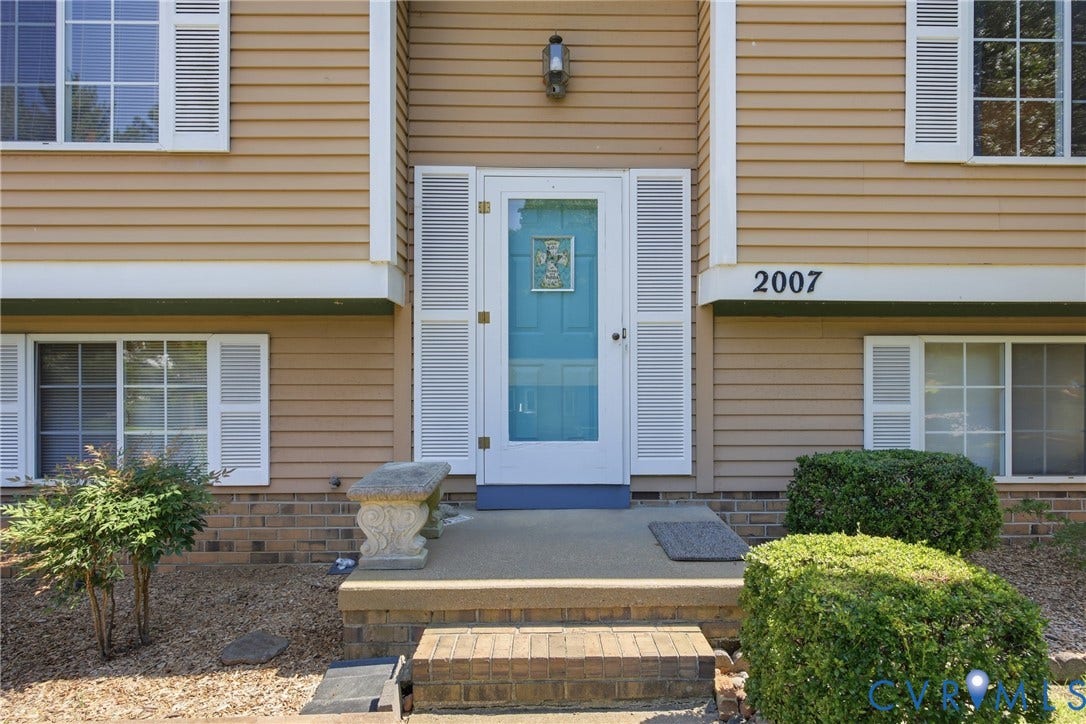 2007 Mountain Pine Boulevard, Three Pines, Richmond, VA 23235 Siding exterior with decorative shutters, a light blue door with a glass insert, and brick foundation