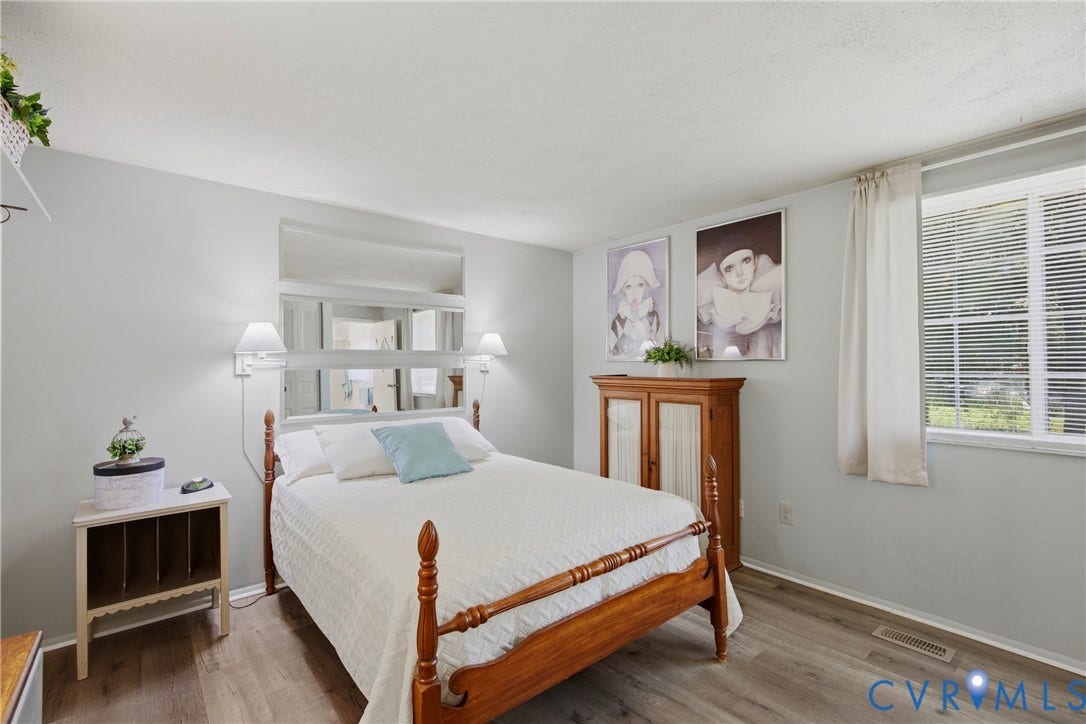 2007 Mountain Pine Boulevard, Three Pines, Richmond, VA 23235 Wood-finish flooring, wall-mounted sconce lighting, and a large window with horizontal blinds
