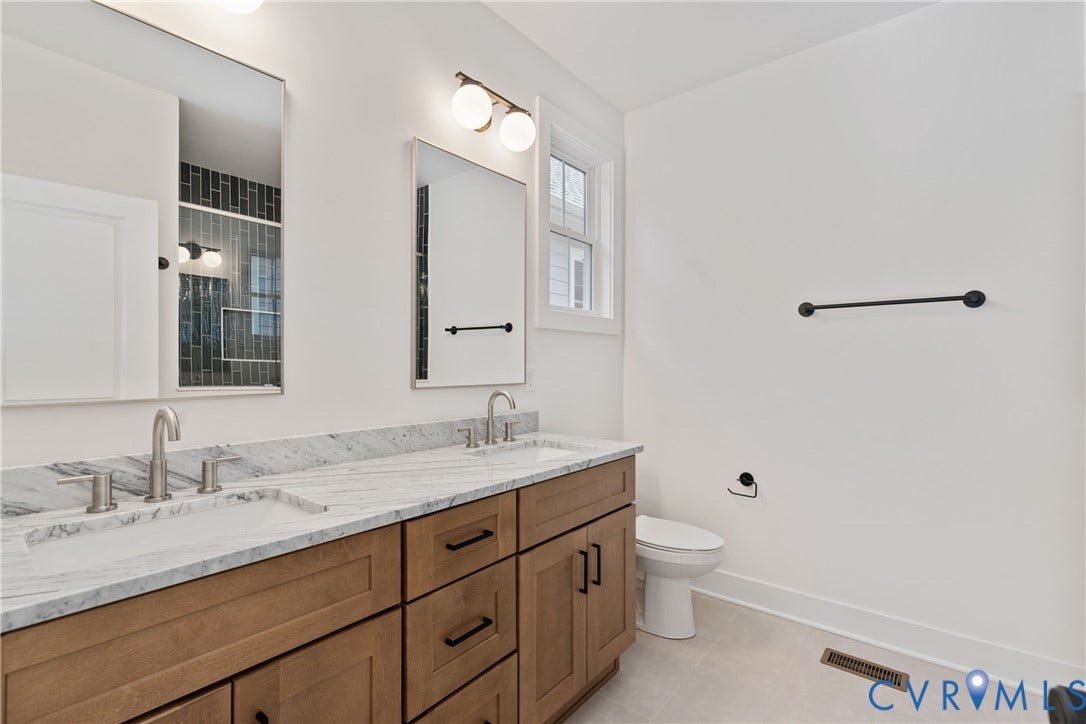 1103 Carlisle Avenue, Montrose Heights, Richmond, VA 23231 Double vanity featuring a light-toned wood-finish cabinet, integrated white sinks, and brushed nickel faucets