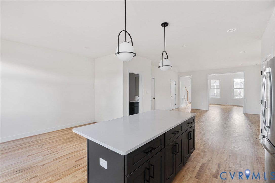 1103 Carlisle Avenue, Montrose Heights, Richmond, VA 23231 Kitchen island featuring a light-toned countertop, dark cabinetry with dark hardware, and two pendant lights