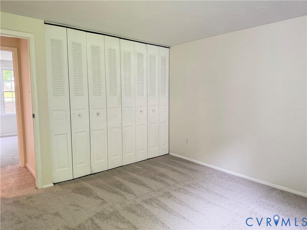1308 Bentbrook Drive, Henrico, VA 23231 Room featuring a full-wall bi-fold louvered closet system, neutral tone carpet, and painted walls