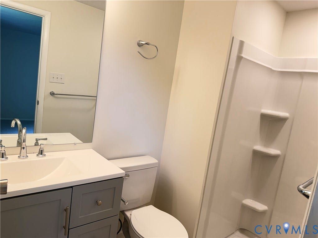 1308 Bentbrook Drive, Henrico, VA 23231 Modern bathroom featuring a gray vanity with rectangular sink, chrome faucet and hardware, white quartz countertop, and ceramic tile surround