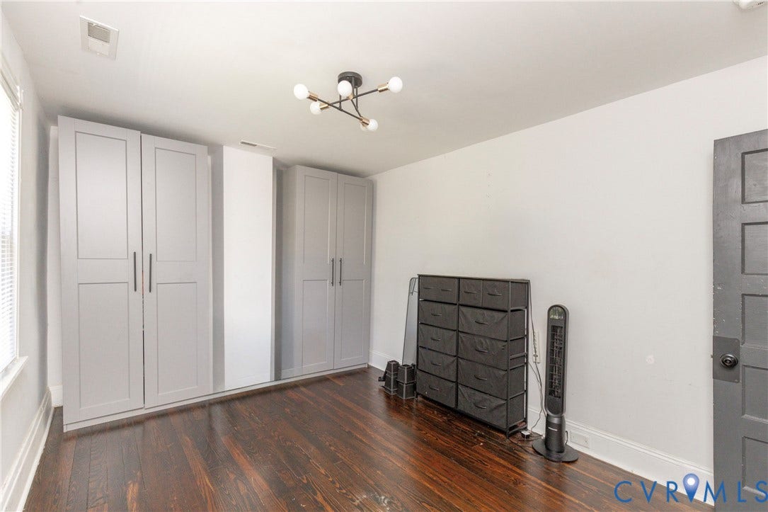 716 E Gladstone Avenue, Richmond, VA 23222 Hardwood flooring, light gray built-in cabinetry, white walls, and a contemporary ceiling light fixture