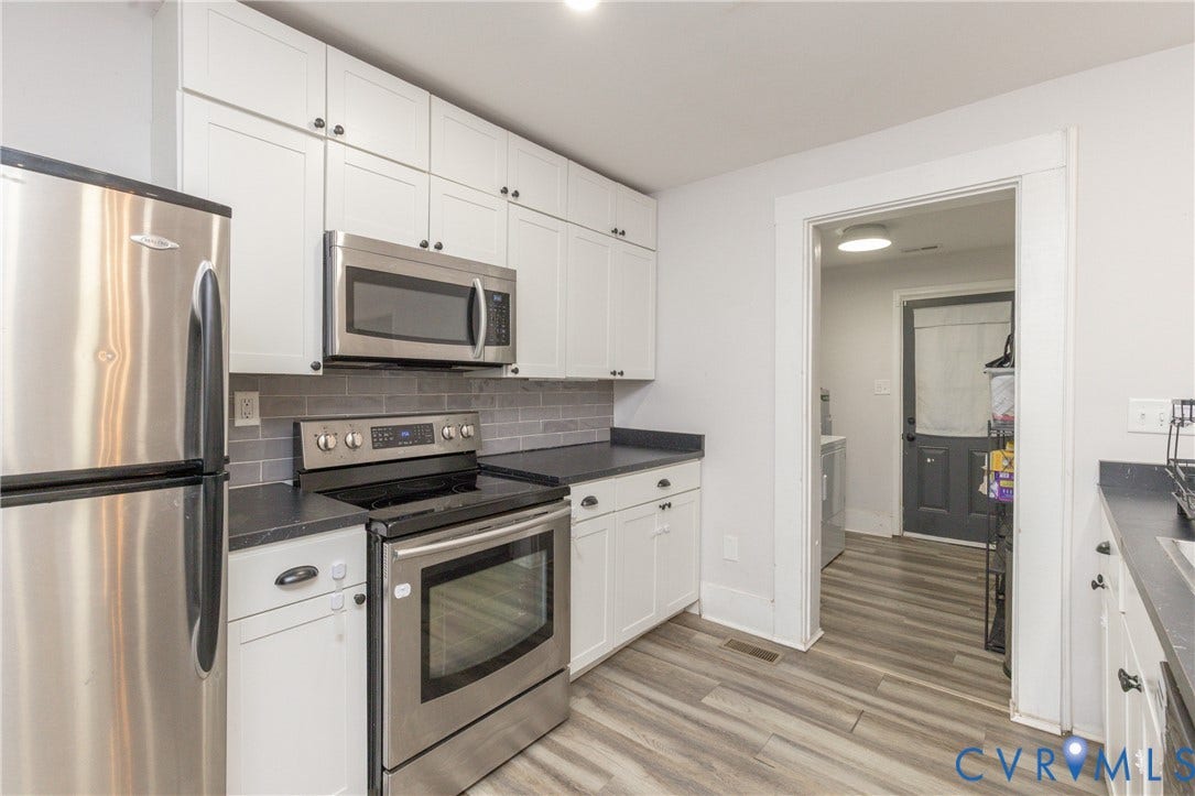 716 E Gladstone Avenue, Richmond, VA 23222 Kitchen featuring white cabinetry, dark countertops, stainless steel appliances, and a subway tile backsplash