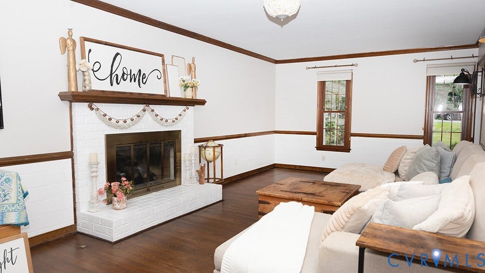 419 Rossmere Drive, Walton Park, Midlothian, VA 23114 Living area featuring a white painted brick fireplace with a wood mantel, rich wood-finish flooring, white walls with horizontal wood trim, and multiple windows with wood frames